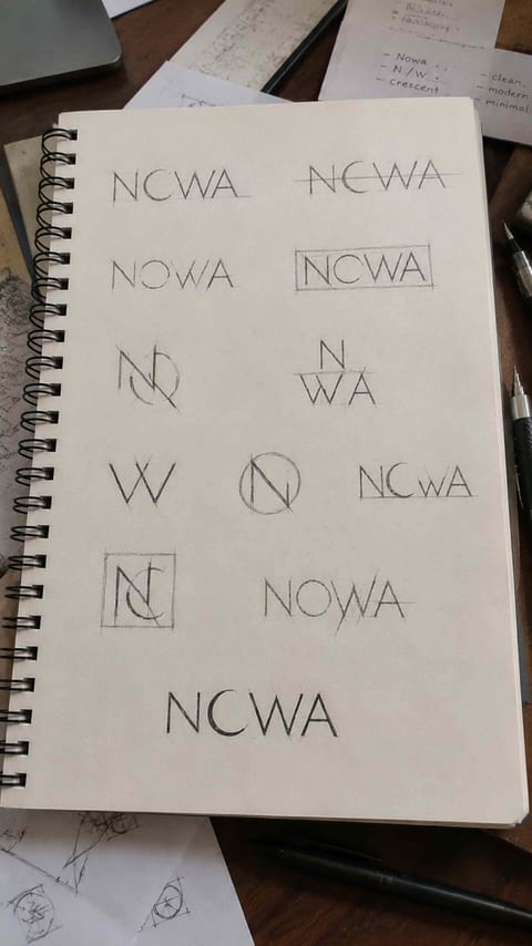 A sketchbook of hand-drawn NOWA logo studies: wordmarks, monograms and crescent-moon ideas in pencil.